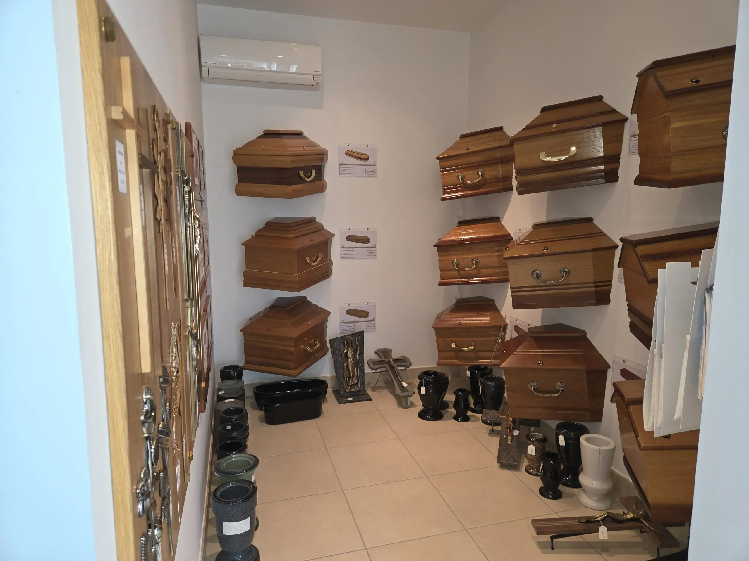 Salle d'exposition présentant une sélection de cercueils en bois.